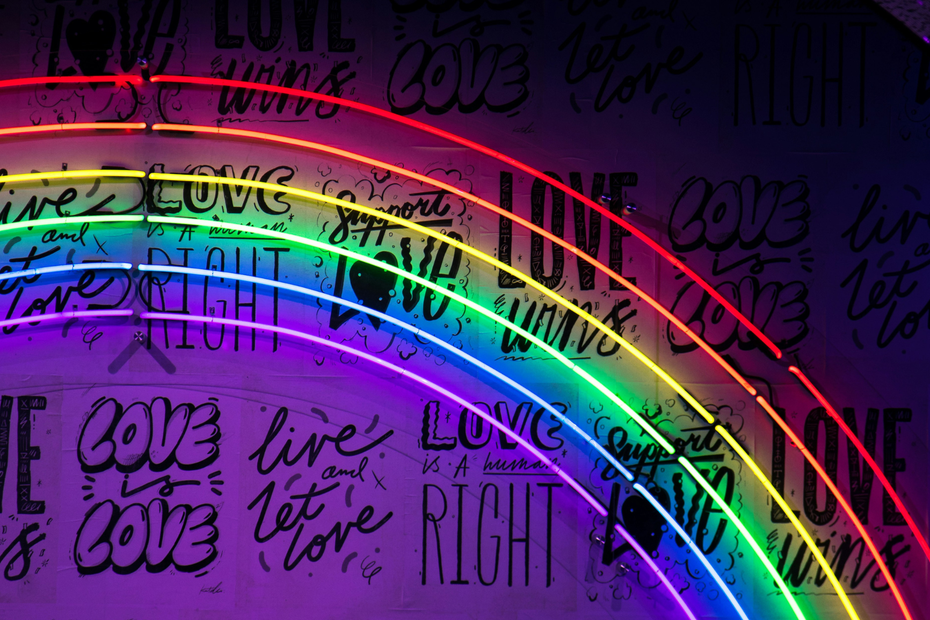 A neon rainbow on a purple wall 